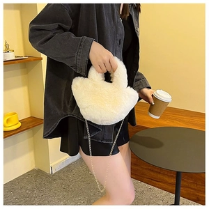 Détail du sac seau en peluche crème avec chaîne dorée et poignée en fourrure douce