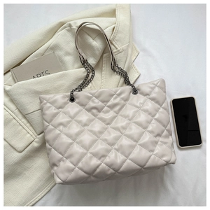 Vue détaillée du sac cabas matelassé beige avec motif losange et chaîne en métal