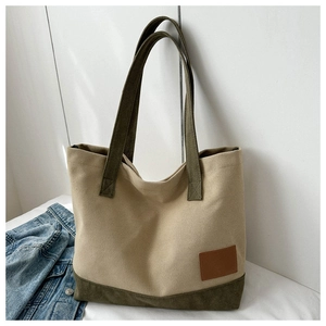 Dettaglio della borsa tote in tela con manici verde oliva e toppa in pelle marrone
