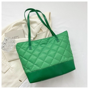 Dettaglio della borsa shopper trapuntata verde smeraldo con base liscia e doppi manici