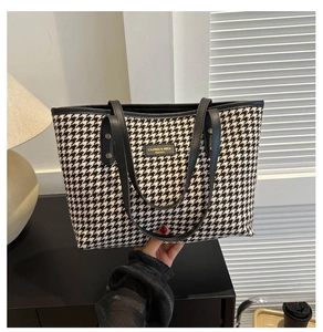 Detailed close-up of houndstooth weave fabric and brand tag on a stylish tote bag