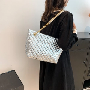 Silver quilted tote bag with gold chain strap shown from a side-rear perspective