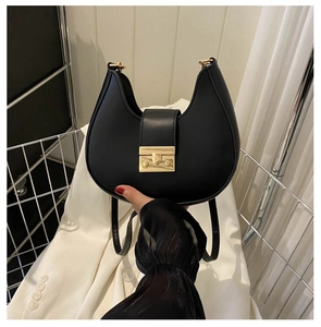 Detail of black crescent shoulder bag featuring premium matte leather and golden buckle clasp