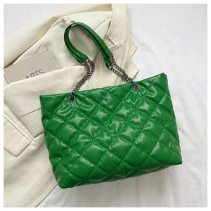 Détail d'un sac cabas vert matelassé avec surpiqûres losanges et chaîne en métal