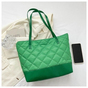 Dettaglio della grande borsa tote trapuntata verde con motivo a rombi e trama in pelle
