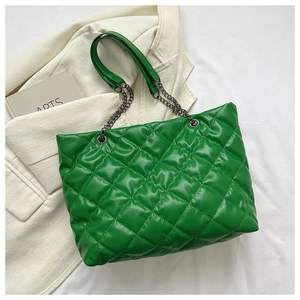 Détail de la texture matelassée verte et de la bandoulière en chaîne du sac à bandoulière