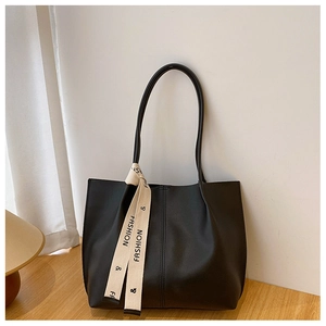 Detail of minimalist black tote bag featuring elegant fashion ribbon and durable texture