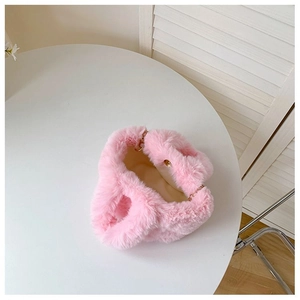 Détail d'un sac seau en peluche rose avec doublure douce et chaîne en métal doré