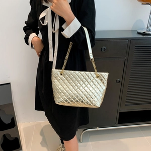 Quilted gold chain tote bag with high-capacity interior and metallic finish texture