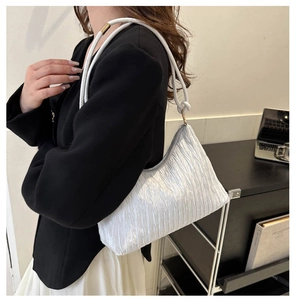 Détail du sac plissé blanc avec texture verticale et bandoulière élégante