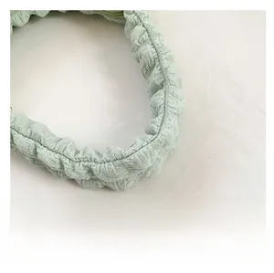 Detailed view of the soft light green ruched handle with cloud texture fabric