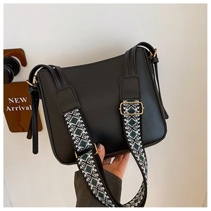 Detail of compact black crossbody bag featuring a bohemian geometric jacquard wide strap