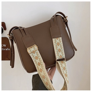 Detail of a dark brown crossbody bag featuring a chic embroidered ethnic wide strap