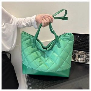 Dettaglio della borsa tote trapuntata verde con manico e interno capiente in nylon