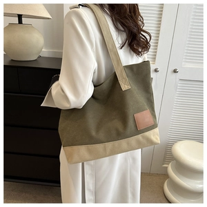 Dettaglio della borsa tote in tela con design patchwork e toppa in pelle decorativa