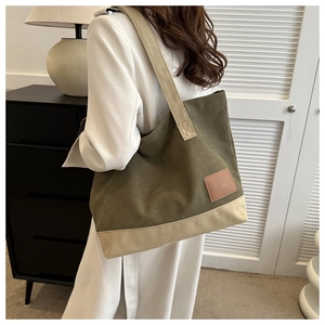 Dettaglio della borsa tote in tela verde militare e beige con inserto in cuoio