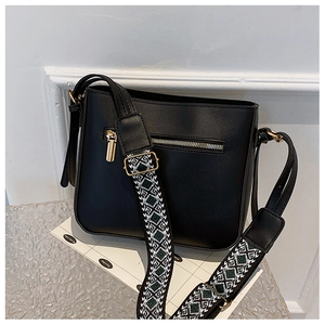 Detailed view of black leather crossbody bag with vintage geometric wide strap and gold hardware