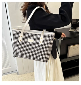 Classic houndstooth tote bag with white leather straps shown in a modern office setting