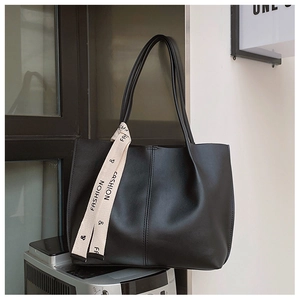 Detail of black matte tote bag with fashion ribbon strap and sturdy shoulder structure