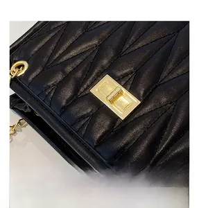 Close-up of black quilted leather bag with gold metal twist lock and luxury chain detail