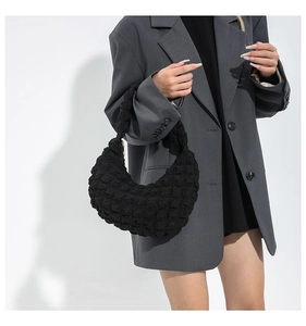 Close-up of black bubble textured cloud bag showing the unique quilted fabric and curved shape