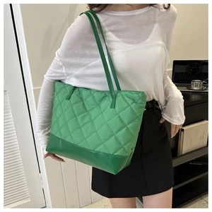 Dettaglio della borsa tote verde trapuntata con motivo a rombi e base rinforzata