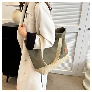 Dettaglio della borsa tote in tela verde militare e beige con inserto in pelle sulla spalla