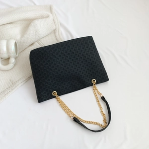 Large black woven tote bag with gold chain strap and geometric texture on white background