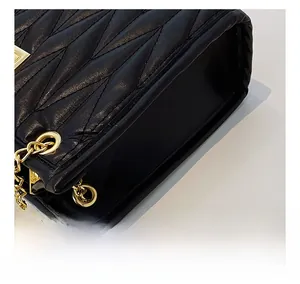Close-up of black matelassé quilted leather and precise stitching detail on handbag