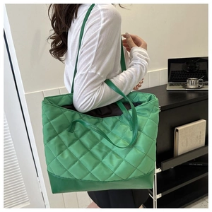 Dettaglio della borsa tote trapuntata verde con cuciture a rombi sulla spalla