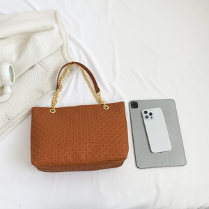 Brown woven texture tote bag with gold chain straps, showing large capacity next to a tablet