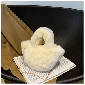 Détail macro du sac seau en fausse fourrure beige avec bandoulière chaîne dorée