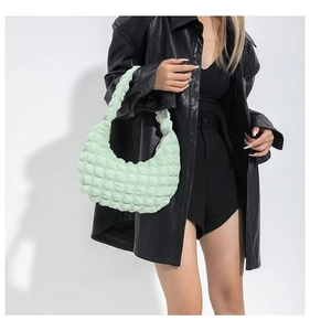 Close-up of mint green bubble texture fabric and ruched handle on a cloud handbag