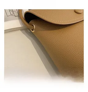 Detail of khaki brown lychee texture leather handbag with light gold metal hardware