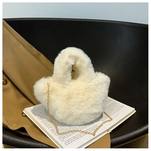 Vue détaillée d'un sac seau en fausse fourrure crème avec bandoulière dorée et texture douce