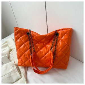 Gros plan du sac cabas matelassé orange avec cuir PU brillant et bandoulière en chaîne