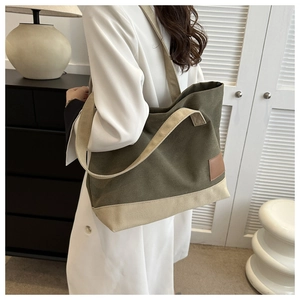 Dettaglio della borsa tote in tela con doppi manici e design a contrasto beige oliva