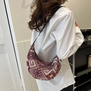 Bohemian woven half-moon crossbody bag with colorful geometric patterns and black strap