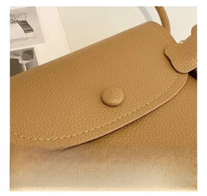 Detailed macro view of brown lychee-textured leather surface with dense sewing stitches