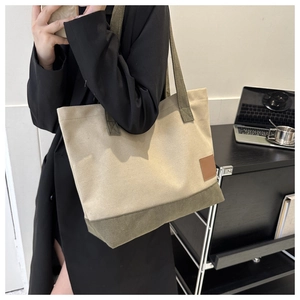 Dettaglio della borsa tote in tela con fondo verde oliva e toppa laterale marrone