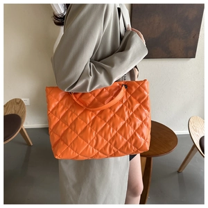 Gros plan détaillé d'un cabas matelassé orange vif avec un motif de couture en losange