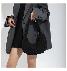 Close-up of black cloud handbag with stylish bubble texture and soft integrated handle