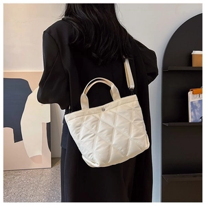 Détail d'un sac cabas blanc matelassé avec boucle argentée et bandoulière
