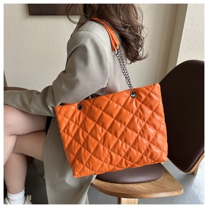 Sac cabas orange matelassé avec bandoulière en chaîne argentée et motif à losanges