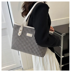 Detail of classic houndstooth tote bag featuring white leather handles and a side view on a model
