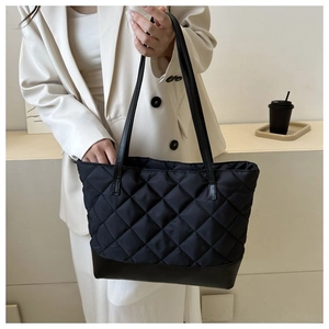 Dettaglio della borsa shopper trapuntata nera con base in pelle e spalline sottili