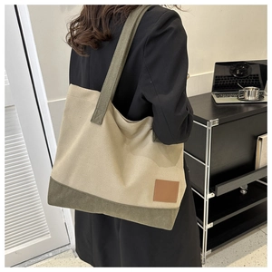 Dettaglio di una grande borsa tote in tela con design color-block oliva e beige