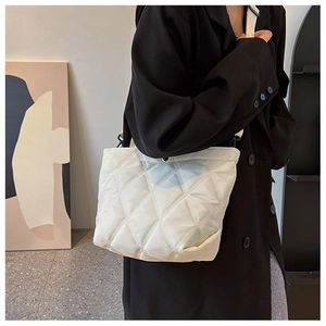 Vue détaillée du sac cabas matelassé blanc à motif losanges porté à l'épaule
