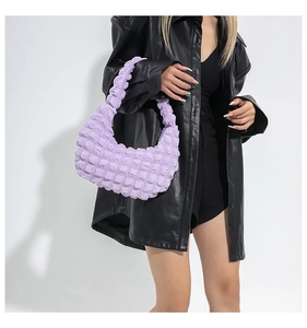 Detailed texture of lavender bubble pleated hobo bag worn with black leather jacket