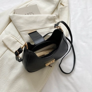 Minimalist black crescent shoulder bag with gold hardware and spacious leather interior